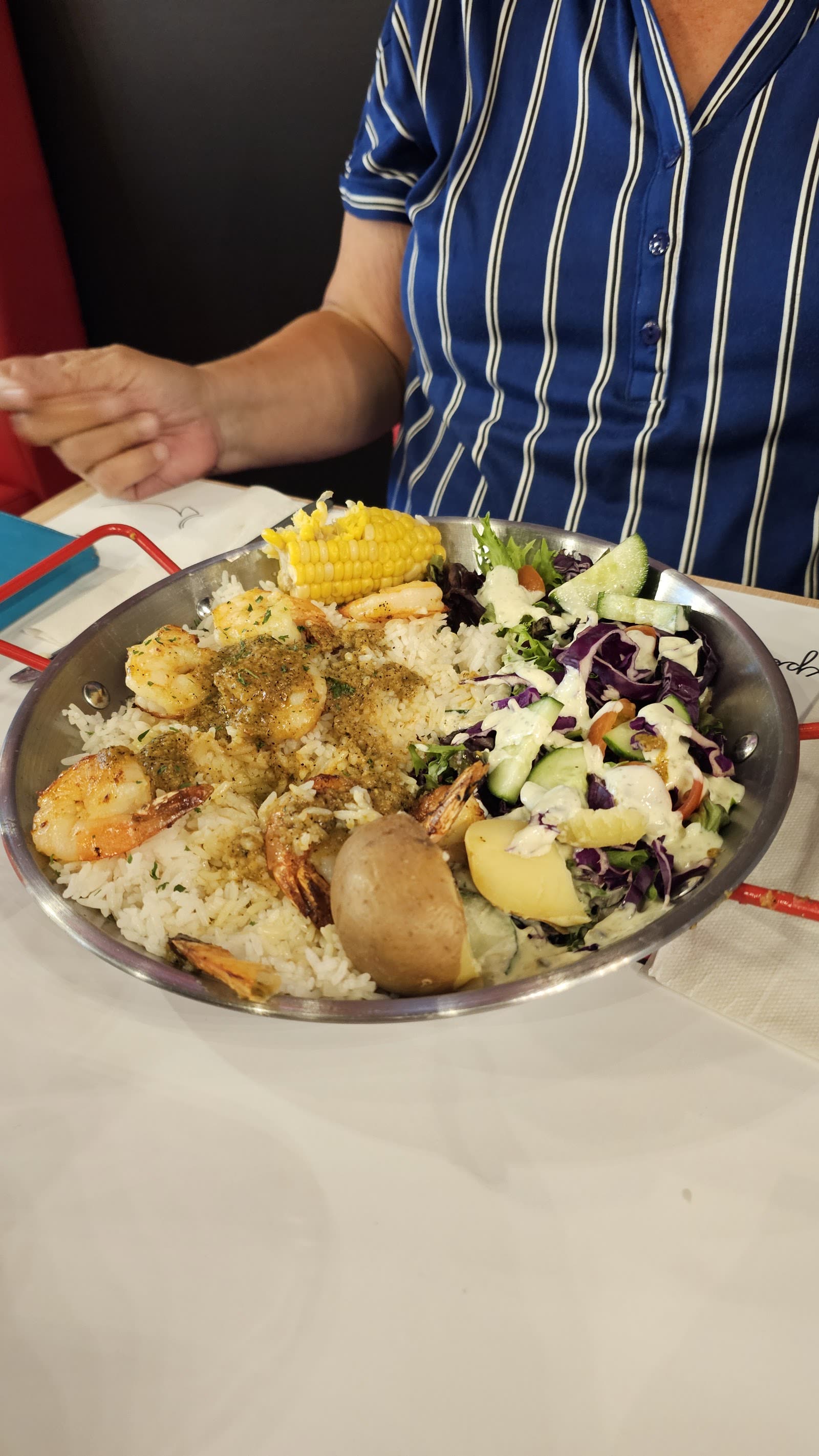 Bol de crevettes avec riz, salade et pommes de terre