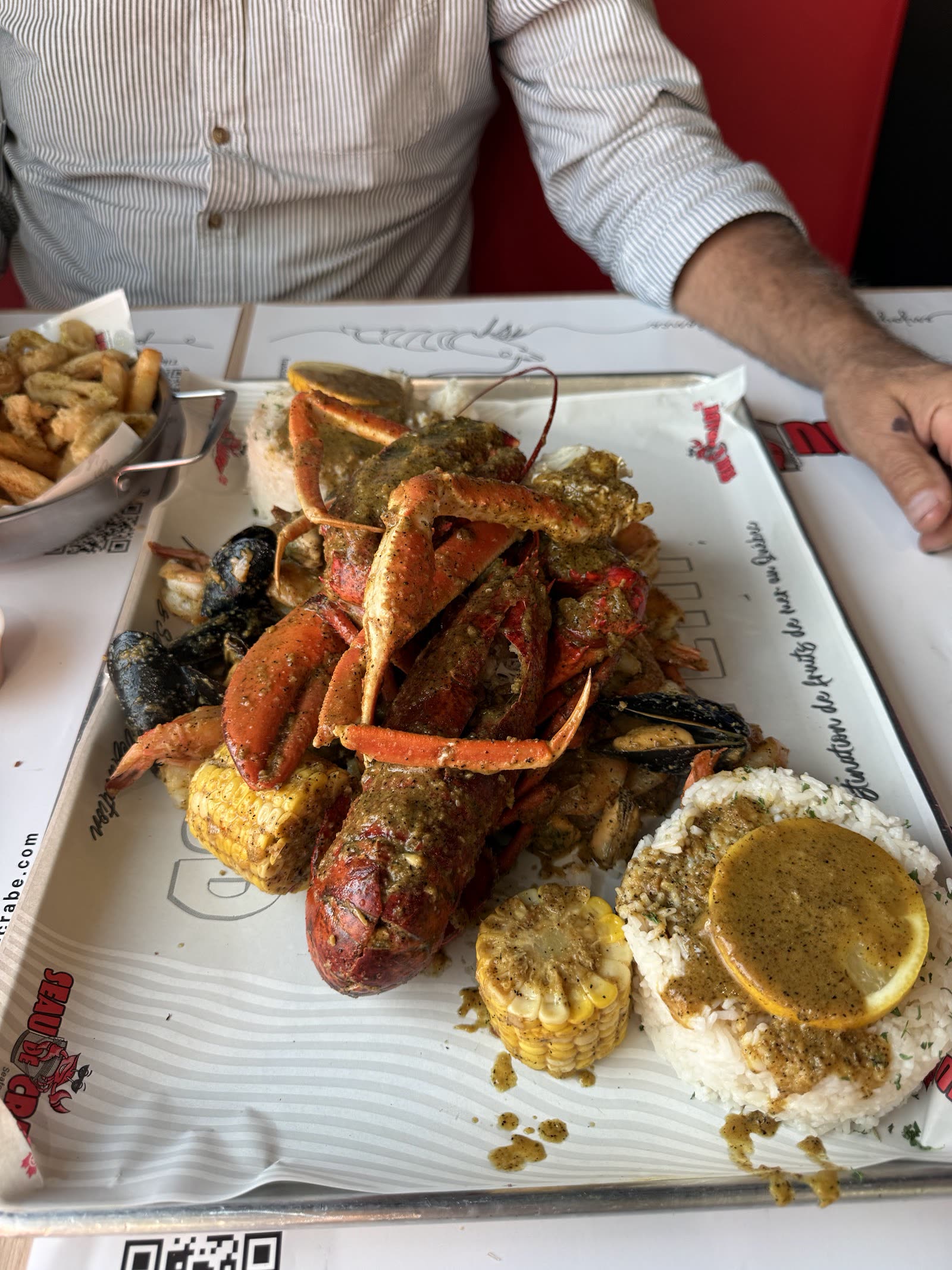 Seau de crabe des neiges, crevettes, moules, maïs et pommes de terre servi sur papier Seau de Crabe