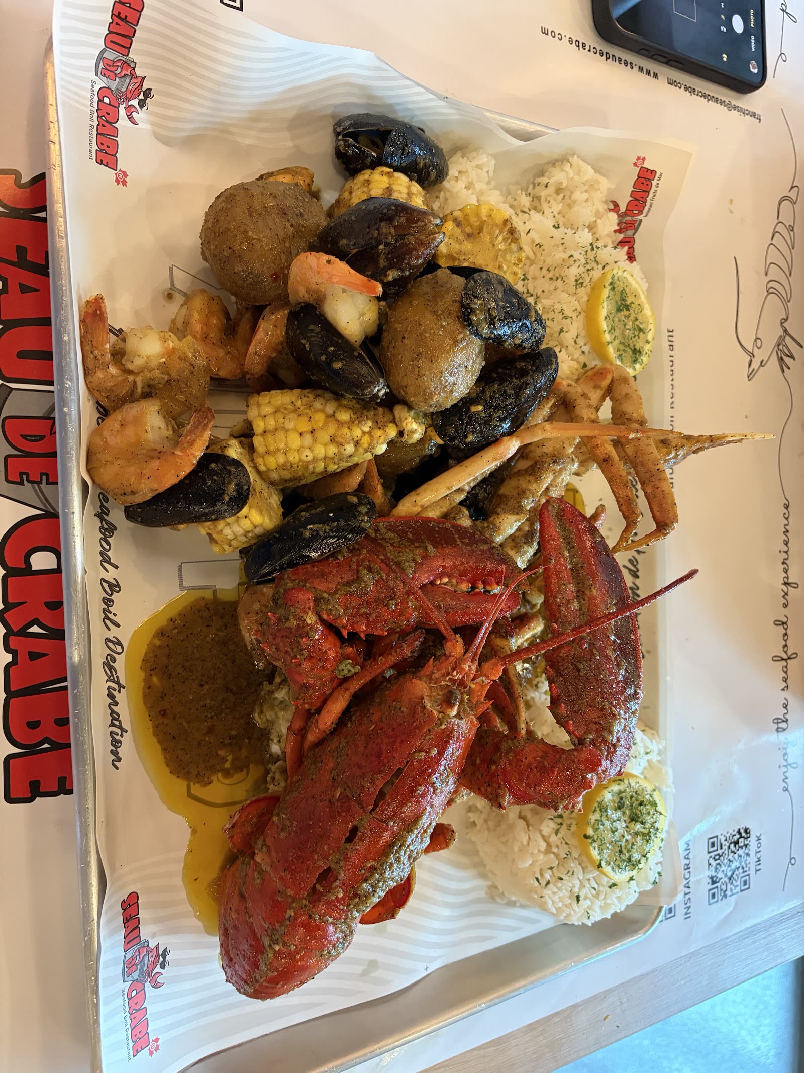 Homard entier, moules, crevettes et maïs sur papier Seau de Crabe