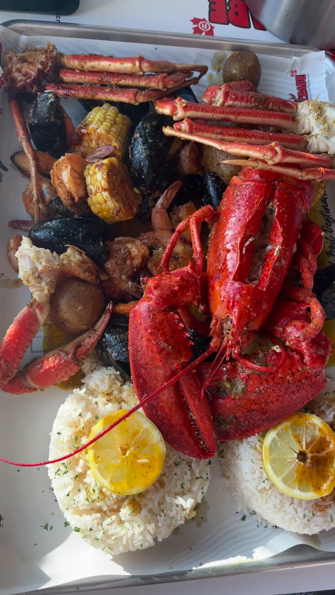 Homard rouge, moules et maïs en gros plan