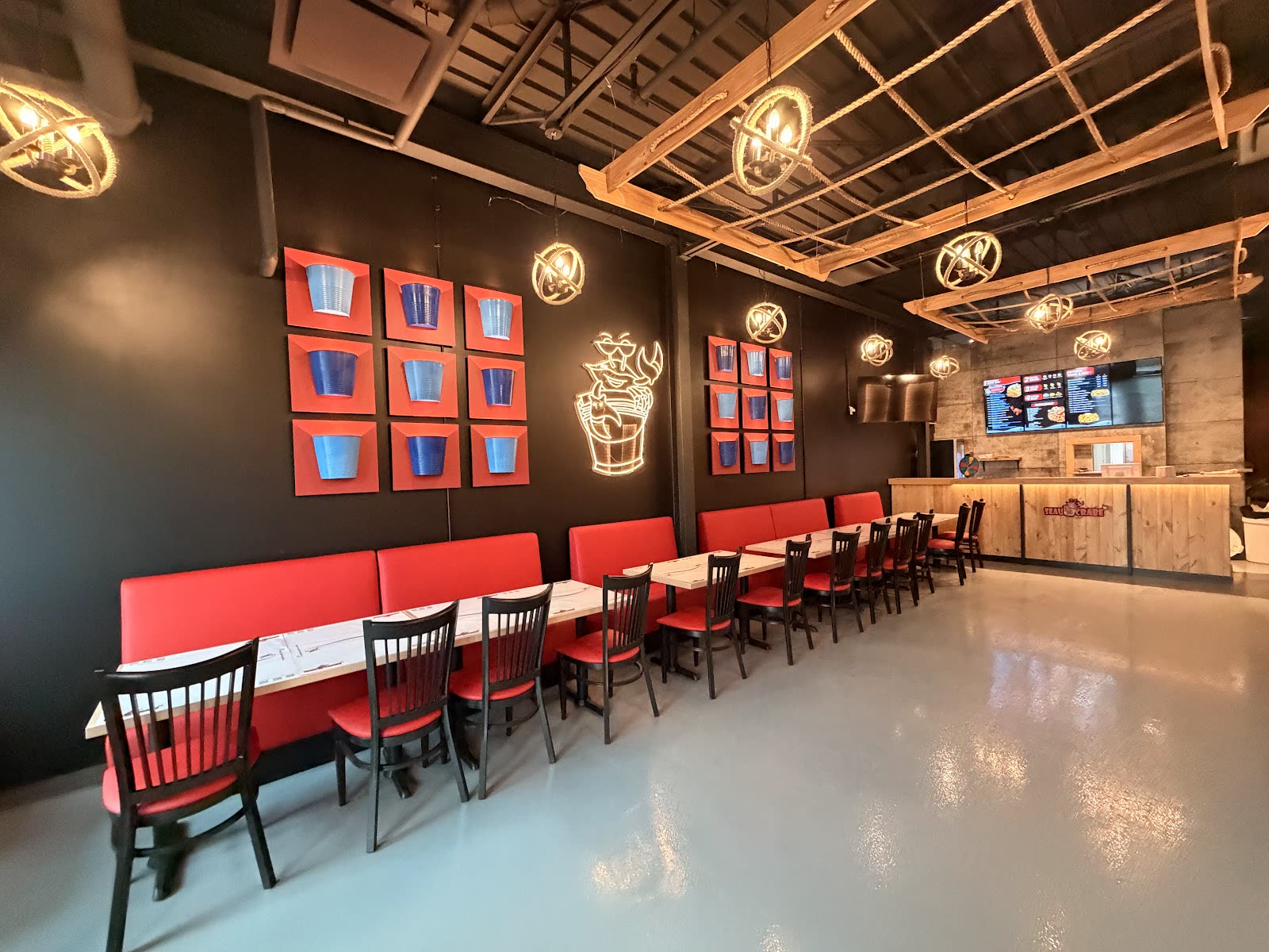 Salle du restaurant avec banquettes rouges et néon crabe